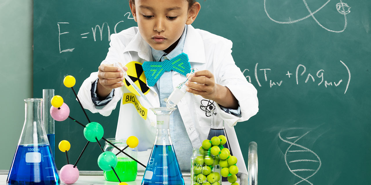 Flicka i vit rock och fluga som leker vetenskapsman